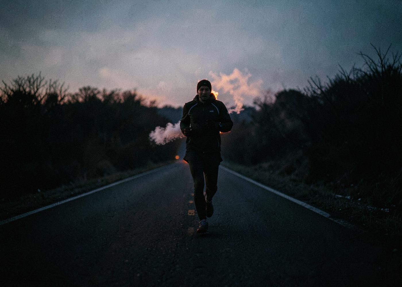 Lone runner on an empty road before dawn